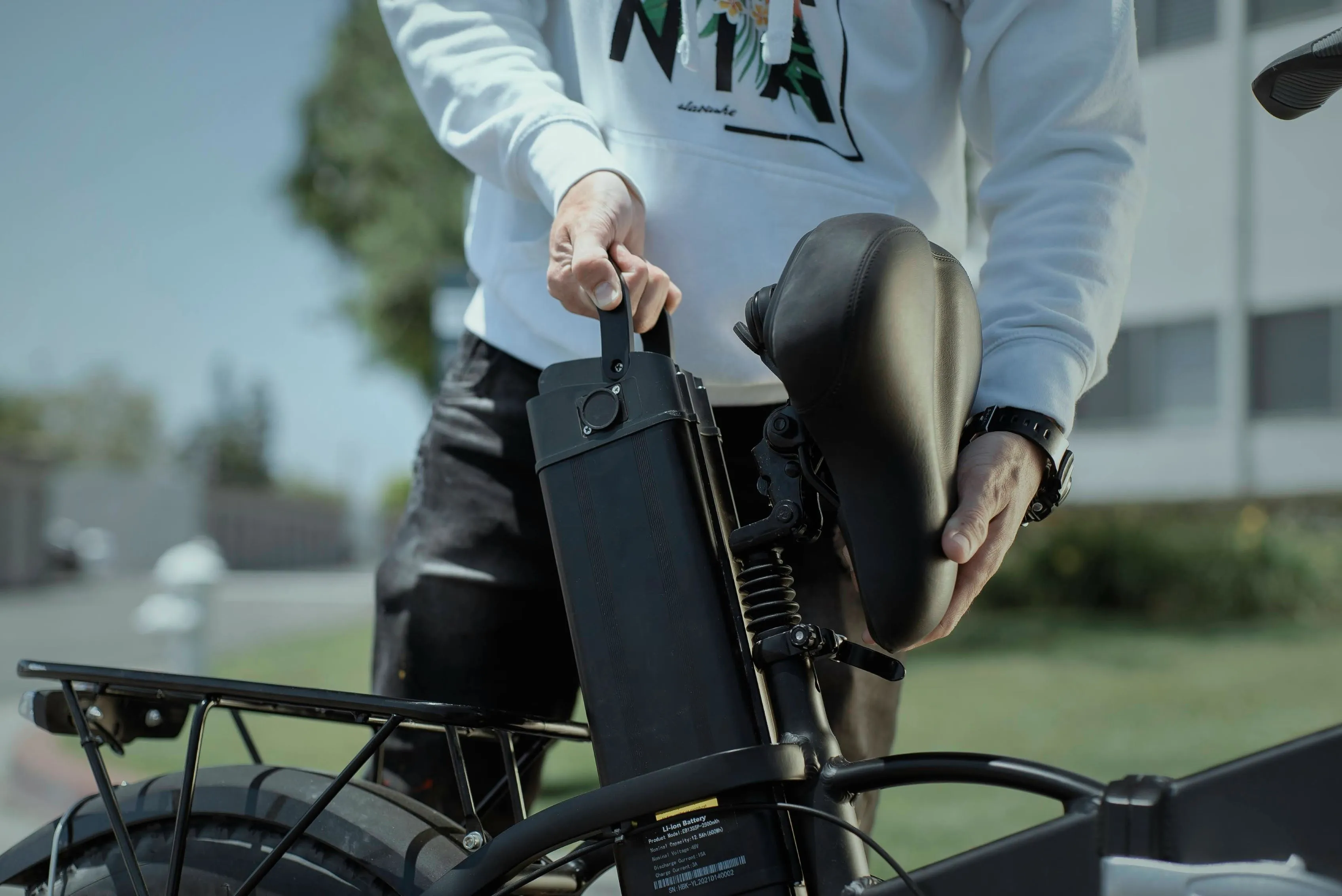 Un homme retire la batterie électrique de son vélo.